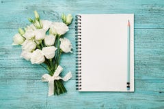 Bouquet of white flowers and empty paper sheet on turquoise rustic table from above. Beautiful vintage card, top view. Royalty Free Stock Photo Bouquet of white flowers and empty paper sheet on turquoise rustic table from above. Beautiful vintage card, top view. Royalty Free Stock Photo