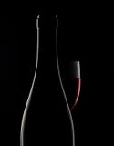 Bouteille de vin rouge et verre de vin sur le fond noir Photos libres de droits Bouteille de vin rouge et verre de vin sur le fond noir Photos libres de droits