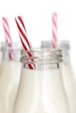 Bouteilles de lait avec les pailles rayées rouges au-dessus du blanc photo libre de droits Bouteilles de lait avec les pailles rayées rouges au-dessus du blanc photo libre de droits