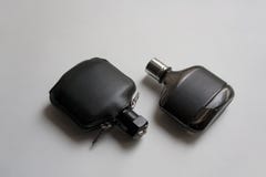 Bouteilles de parfum de cuir noir et en verre foncé photographie stock Bouteilles de parfum de cuir noir et en verre foncé photographie stock