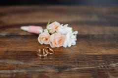Boutonniere with rings on the wooden floor stock images Boutonniere with rings on the wooden floor stock images