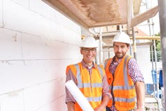 Bouwmanager en architect op plaats tijdens de bouw van een huis - planning en controle op plaats - groepswerk stock fotografie Bouwmanager en architect op plaats tijdens de bouw van een huis - planning en controle op plaats - groepswerk stock fotografie