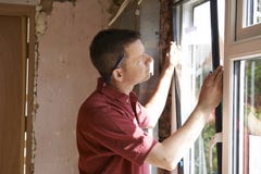 Bouwvakker Installing New Windows binnenshuis royalty-vrije stock foto Bouwvakker Installing New Windows binnenshuis royalty-vrije stock foto