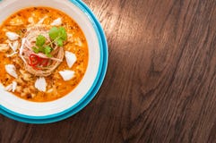 A bowl of Crab meat curry with vermicelli, Crab meat Laksa on wood table stock photo A bowl of Crab meat curry with vermicelli, Crab meat Laksa on wood table stock photo