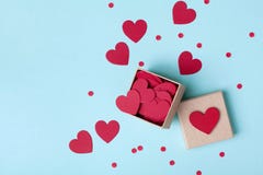 Boxen Sie voll von den roten Herzen und von den Konfettis auf blauer Tischplatteansicht Rosa Herz zwei flache Lageart Boxen Sie voll von den roten Herzen und von den Konfettis auf blauer Tischplatteansicht Rosa Herz zwei flache Lageart