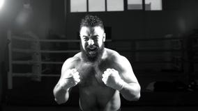 Boxeur mâle Le jeune homme pratique ses mouvements de boxe Poinçons de lancement de boxeur intense d'homme image libre de droits Boxeur mâle Le jeune homme pratique ses mouvements de boxe Poinçons de lancement de boxeur intense d'homme image libre de droits