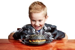Boy in black gloves emotionally eating a burger stock photography Boy in black gloves emotionally eating a burger stock photography