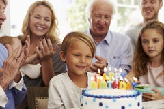 Boy Blows Out Birthday Cake Candles At Family Party stock photo Boy Blows Out Birthday Cake Candles At Family Party stock photo