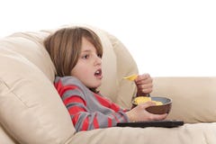 Boy Eating Chips And Watching Television Royalty Free Stock Photo