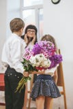 Boy and girl give flowers as a school teacher in teacher`s day stock photos Boy and girl give flowers as a school teacher in teacher`s day stock photos