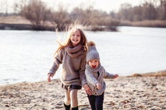 A boy and a girl having fun outside in early spring in the forest near the water. A sister and brothe together. stock photo A boy and a girl having fun outside in early spring in the forest near the water. A sister and brothe together. stock photo