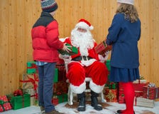 Boy and Girl receiving gifts from Santa royalty free stock photos Boy and Girl receiving gifts from Santa royalty free stock photos