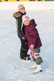 Boy and girl skating on rink hand in hand in winter Royalty Free Stock Image Boy and girl skating on rink hand in hand in winter Royalty Free Stock Image