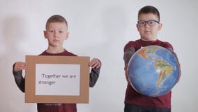 Boy Holds A Globe, A Model Of The Planet Earth. Child Is Holding A Sign With The Inscription: TOGETHER WE ARE STRONGER Royalty Free Stock Photography Boy Holds A Globe, A Model Of The Planet Earth. Child Is Holding A Sign With The Inscription: TOGETHER WE ARE STRONGER Royalty Free Stock Photography