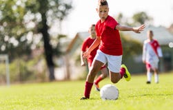 Boy kicking football on the sports field stock image Boy kicking football on the sports field stock image