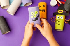 Boy Makes Halloween Toys From Paper. Toilet Roll Tube By Hands. Creative DIY For Kids On Traditional Purple Backgrpund. Home Decor Stock Photography Boy Makes Halloween Toys From Paper. Toilet Roll Tube By Hands. Creative DIY For Kids On Traditional Purple Backgrpund. Home Decor Stock Photography