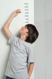 Boy Measuring His Height Stock Images