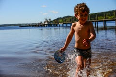 Boy Playing In The Water Stock Photos
