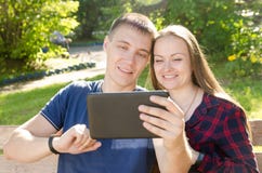 Boy and smiling girl chat over the internet on a tablet with friends stock photography Boy and smiling girl chat over the internet on a tablet with friends stock photography