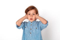 Boy studio standing isolated on grey covering ears confused stock photo Boy studio standing isolated on grey covering ears confused stock photo