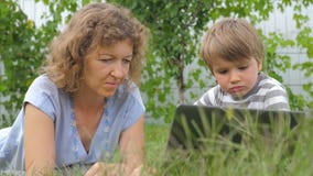 Family background. Mother and child concept. Technologies and children. Boy with teacher background. Mother and child. lying on grass. Alternative education Family background. Mother and child concept. Technologies and children. Boy with teacher background. Mother and child. lying on grass. Alternative education