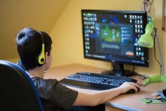 Boy Using Computer At Home, Playing Game Royalty Free Stock Photos