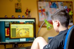 Boy Using Computer At Home, Playing Game Stock Photo