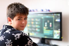 Boy using computer at home, playing game stock images Boy using computer at home, playing game stock images