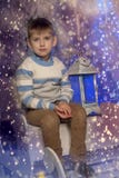 Boy in a warm sweater sitting on a sleigh stock photo Boy in a warm sweater sitting on a sleigh stock photo