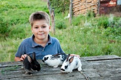 Boy With A Rabbit In The Garden Stock Photo