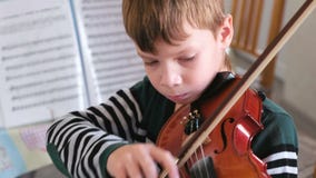 Boy of 8 years is playing violin.