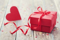 Boîte-cadeau avec le ruban rouge d'arc et coeur de papier sur la table pour le jour de valentines photos stock Boîte-cadeau avec le ruban rouge d'arc et coeur de papier sur la table pour le jour de valentines photos stock
