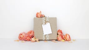 Boîte-cadeau avec une maquette d'étiquette, fleurs oranges image stock Boîte-cadeau avec une maquette d'étiquette, fleurs oranges image stock