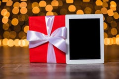 Boîte-cadeau et tablette se tenant sur le plancher Images stock Boîte-cadeau et tablette se tenant sur le plancher Images stock