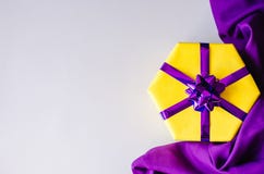 Boîte-cadeau jaune avec un arc pourpre photographie stock libre de droits Boîte-cadeau jaune avec un arc pourpre photographie stock libre de droits