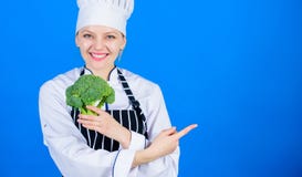 Br?colis da posse do cozinheiro chefe da mulher que apontam no espa?o da c?pia Receitas saud?veis do vegetariano Fatos de surpres foto de stock Br?colis da posse do cozinheiro chefe da mulher que apontam no espa?o da c?pia Receitas saud?veis do vegetariano Fatos de surpres foto de stock