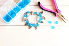 Bracelet fait main avec des fleurs, des perles et des pendants en métal Organisateur avec des accessoires pour faire des bijoux image libre de droits Bracelet fait main avec des fleurs, des perles et des pendants en métal Organisateur avec des accessoires pour faire des bijoux image libre de droits