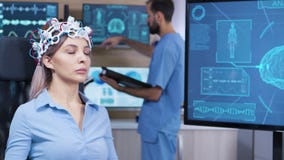 Brain activity on tv screen from female patient with brainwaves scanning headest