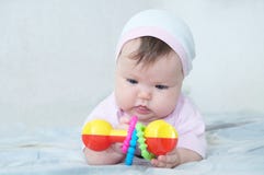 Brain Development temprano pequeño bebé concentrado que juega con traqueteo Fotografía de archivo libre de regalías Brain Development temprano pequeño bebé concentrado que juega con traqueteo Fotografía de archivo libre de regalías