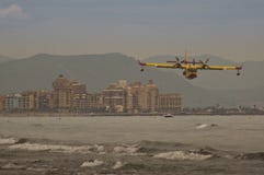 Brandbekämpningflygplan som flyger över havet på stranden arkivfoto Brandbekämpningflygplan som flyger över havet på stranden arkivfoto