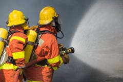 2 brandbestrijders die water in brandbestrijding met donkere rook B bespuiten royalty-vrije stock foto's 2 brandbestrijders die water in brandbestrijding met donkere rook B bespuiten royalty-vrije stock foto's