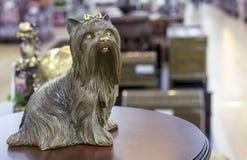 Brass statuette of the Yorkshire Terrier on a round wooden table royalty free stock photography Brass statuette of the Yorkshire Terrier on a round wooden table royalty free stock photography
