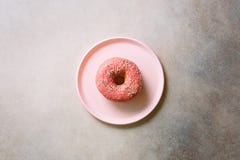 Breakfast concept. Donut on pink plate over concrete background with copy space. Top view, flat lay stock photography Breakfast concept. Donut on pink plate over concrete background with copy space. Top view, flat lay stock photography