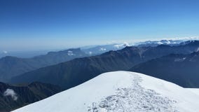A breathtaking view from the top of Mount Kazbek. A panorama of impregnable snow-capped mountains