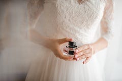 Bride with French manicure holds a bottle of perfume stock photography Bride with French manicure holds a bottle of perfume stock photography