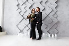 Bride and groom portrait in studio. Isolated on gray geometric background. Dry ice smoke on floor royalty free stock photography Bride and groom portrait in studio. Isolated on gray geometric background. Dry ice smoke on floor royalty free stock photography