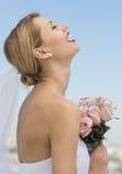 Bride With Her Head Back Holding Flower Bouquet Against Sky Stock Photo Bride With Her Head Back Holding Flower Bouquet Against Sky Stock Photo