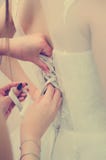 Bridesmaids помогают зашнуровать вверх оплетку на платье тонизировать instagram стиля стоковое изображение rf Bridesmaids помогают зашнуровать вверх оплетку на платье тонизировать instagram стиля стоковое изображение rf