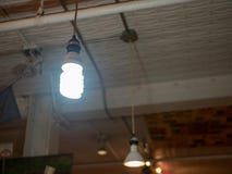 Bright florescent coil light bulb hanging in warehouse stock image Bright florescent coil light bulb hanging in warehouse stock image