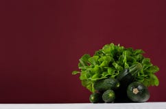 Bright green vegetables on white wood board and burgundi background with copy space. Royalty Free Stock Photo Bright green vegetables on white wood board and burgundi background with copy space. Royalty Free Stock Photo